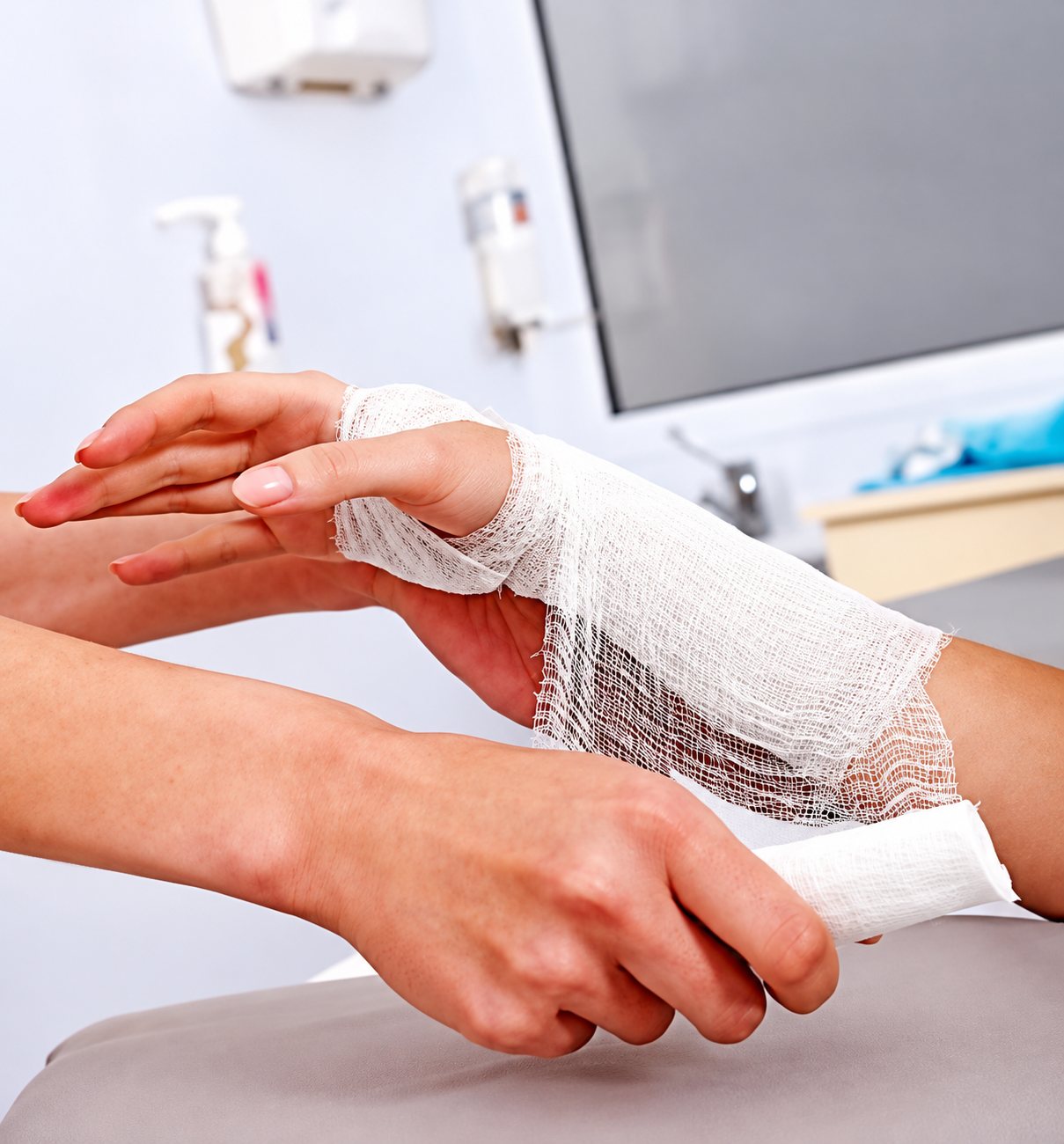 Pose d’un bandage de gaze sur la main d’un patient